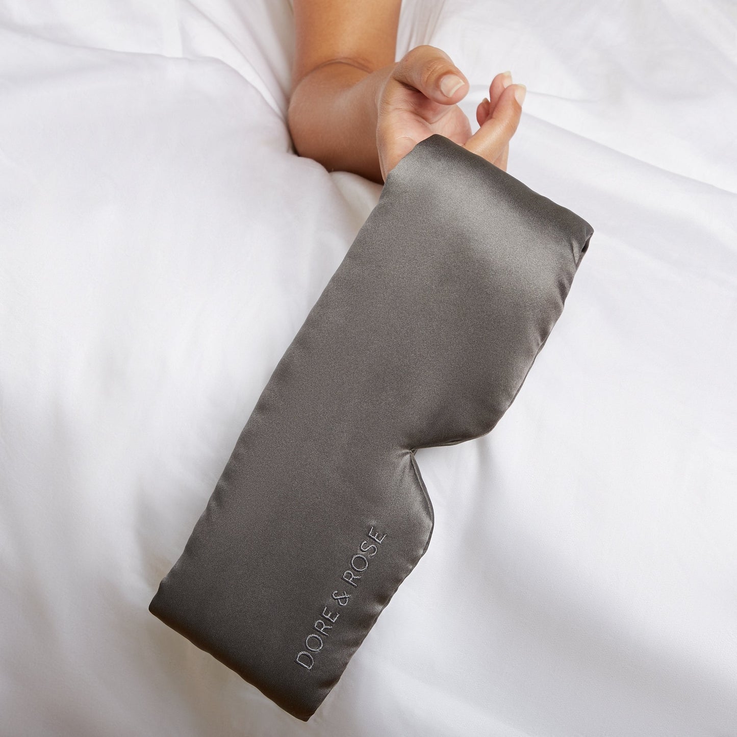 Hand of a woman holding a Silk Gray Sleeping Eyemask