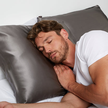 Man sleeping on a pillow with gray silk pillowcase