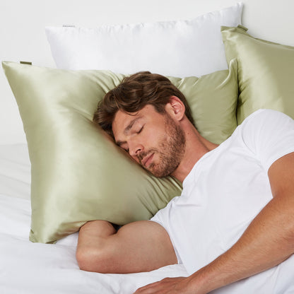 Man sleeping in bed using a  pillow in a Silk Pillowcase from Dore and Rose in the color Olive Green
