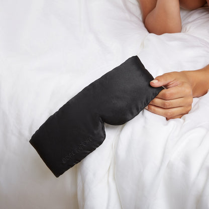 Woman's hand holding a Black Silk Sleeping Eyemask